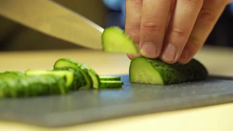 Cucumbers cutting process. A man holds a vegetable in his hands. Stock Footage 135838257
