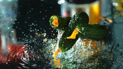 Cucumbers fall on a table with water in slow motion 4k, macro, high speed camera Stock Footage 114977168
