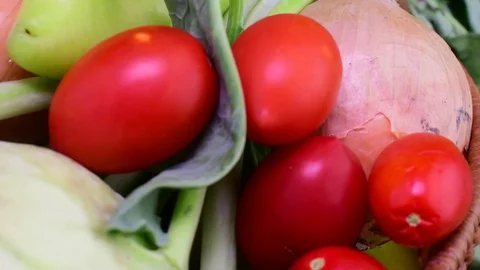 Cucumbers, onions, garlic, tomatoes, kohlrabi and pepers in wicker basket on Stock Footage