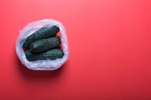 Cucumbers in plastic bag on a red background Stock-Fotos