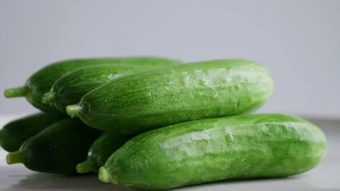 Cucumbers rotates on a white background. Fresh green cucumbers stacked on top of Stock Footage 306603202