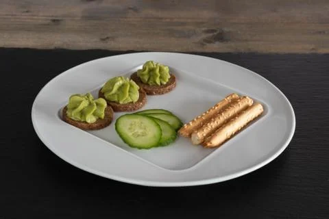 Cucumbers on a white plate with slices of bread. Stock Photos