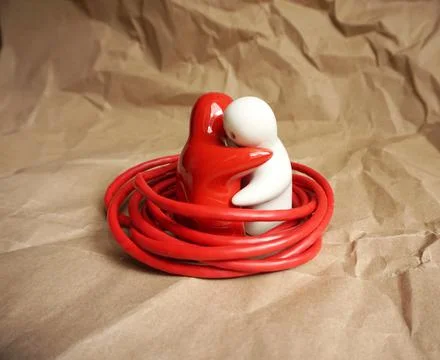 Cuddled icons in red and white color symbolically wrapped in cable Stock Photos