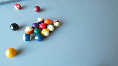 Cue ball breaking the rack on a billiards table at the start of a pool game Stock Footage 340971634