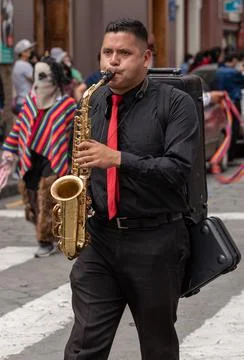Cuenca, Ecuador, Dec 24, 2021 - Man plays saxiphone in the traditional Travel Stock Photos