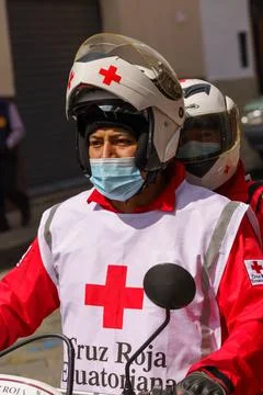 Cuenca, Ecuador, Dec 24, 2021 - Man rides motorcycle in COVID mask and Red Cr Stock Photos