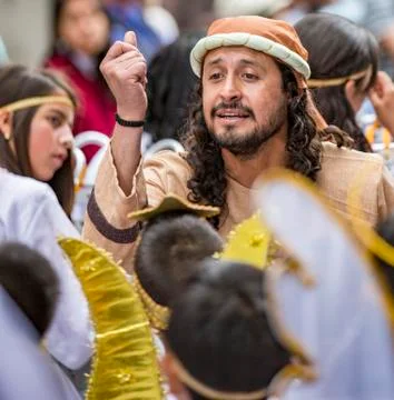 Cuenca, Ecuador - December 24, 2015 - Man directs children dressed as angels  Stock Photos