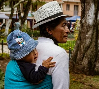 Cuenca, Ecuador, Jan 13, 2018: Ecuadorian indigenous woman carries baby on he Stock Photos