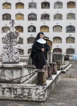 Cuenca, Ecuador - November 1, 2015 -a Catholic nun stands in front of wall of Stock-Fotos