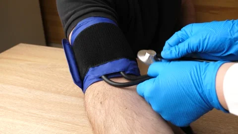 A cuff is placed on the arm and blood pressure is measured. Video stock 274063243