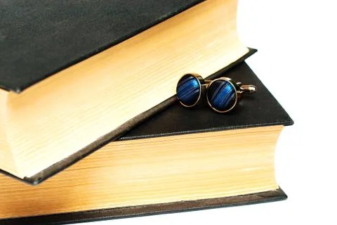 Cufflinks lying on the book Stock Photos