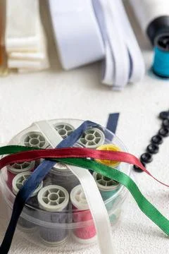 Cufflinks, Sewing Materials, Colorful Threads, and Scissors on a White Surface Foto stock