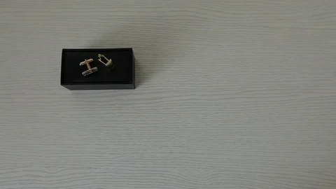 Cufflinks on a white table and on a black box. Stock Footage 80894792