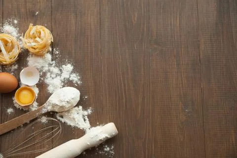Cuisine composition with cracked eggs,kitchenware, flour Stock Photos