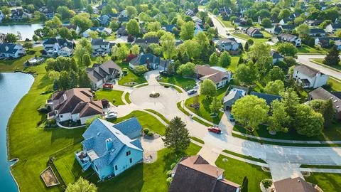 Cul-de-sac with large to middleclass homes in neighborhood with pond in Stock-Fotos