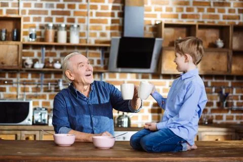 Cule little boy drinking tea with his gramdfather Stock Photos