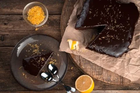 Culinary background with chocolate cake with lemon and zest on a wooden Foto stock