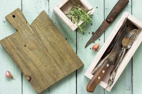Culinary background. Cutting board, garlic and rosemary. Stock Photos