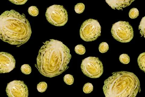 Culinary background. Halfs of cut white cabbage on black background. Stock Photos