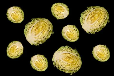 Culinary background. Halfs of cut white cabbage on black background. Stock Photos