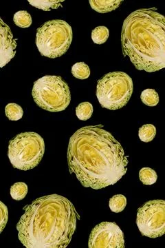 Culinary background. Halfs of cut white cabbage on black background. Stock Photos