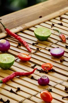 Culinary background. Pattern of fresh vegetables and spices on the bamboo. Stock Photos