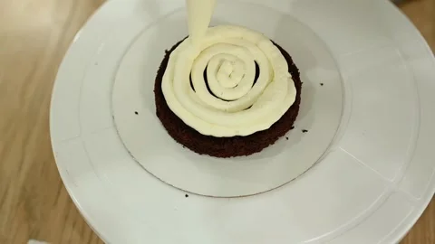 A culinary bag decorates a chocolate cake with buttercream. Stock Footage 242282447