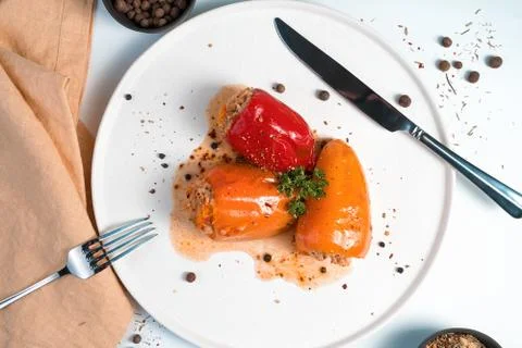 Culinary composition with red and orange peppers decorated with parsley and Stock Photos