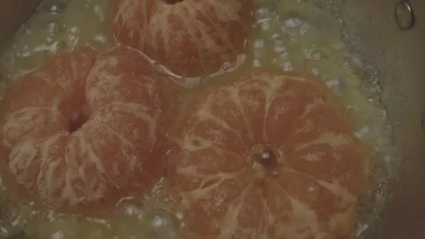 Culinary demonstration in a miniature kitchen focusing on frying citrus segments Video stock 286901840