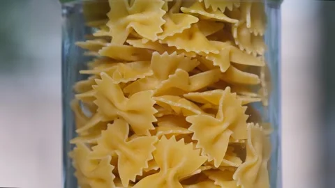Culinary Heritage: Rotating Transparent Jar with Farfalle Pasta Video stock 274668898