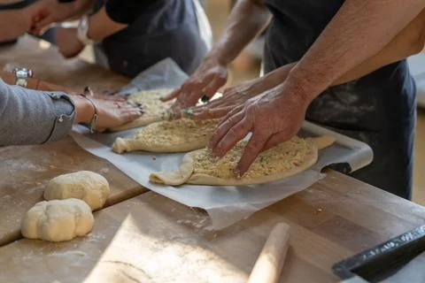Culinary master class. Closeup of people hands preparing khachapuri. Traditio Stock-Fotos