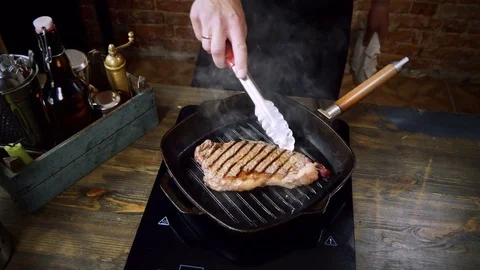 Culinary. One beef steak is being turned over and fried in a broiler pan. 4K 스톡 동영상 84233525