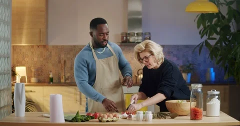 Culinary process of concentrated mixed race young family standing next to Stock Footage 123670301