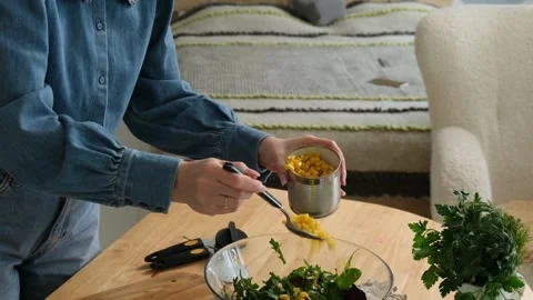 Culinary process of a woman preparing a healthy vegetable salad, adding sweet 库存影片 345048196