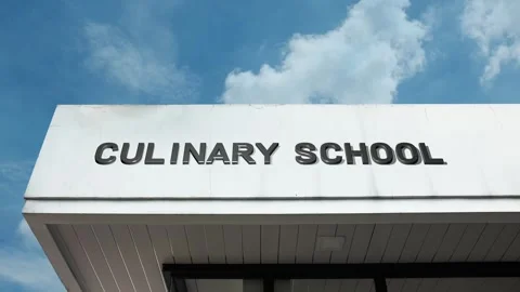 Culinary school word sign displayed on building with blue sky background 動画素材 318602990