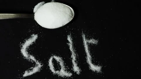 Culinary seasoning ingredient featuring white salt crystals on black surface Stock Footage 336646029