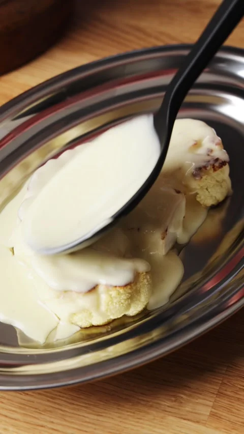 Culinary student pours cheese sauce over cauliflower. Video stock 343006170