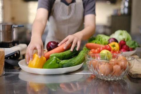 Culinary student standing confidently in training kitchen with fresh ingred.. Stock Photos
