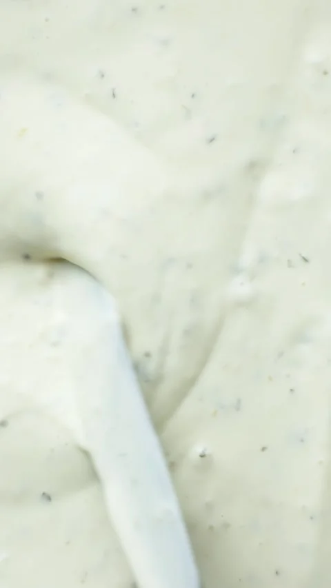 Culinary vertical background with a spatula sliding through thick white garlic d Stock-Footage 341576036