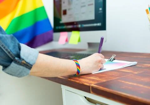 Cultura LGBTQIA. Woman working in office with LGBT accessories. Stock Photos