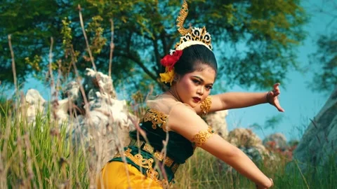 Cultural dancer executing precise hand gestures in tall grass Video stock 280607163