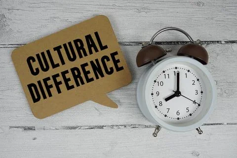 Cultural Difference text with alarm clock on wooden background Stock Photos