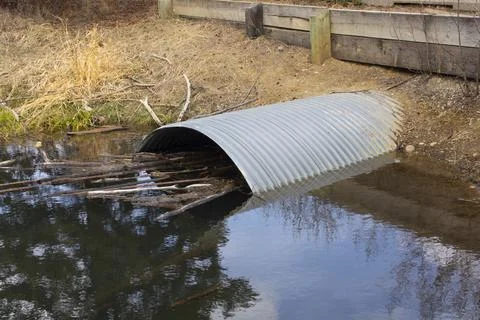 Culvert Pipe Under Road From Stream Oxbow in Park Stock Photos