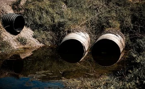 Culvert system guides stormwater through ditch. Culvert flow supports susta.. Stock Photos