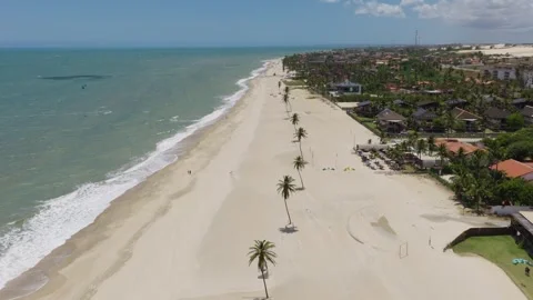 Cumbuco Beach coastline with palm lined promenade Ceará Brazil drone pullback Video stock 334121609