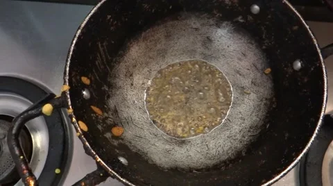 Cumin is  being deep fried in a wok/Indian domestic kitchen/seasoning vegetable Stock-Footage 40522061