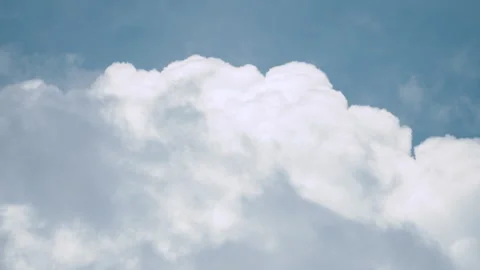 A cumulonimbus cloud passed over white clouds againts a blue sky. Stock Footage 329560758
