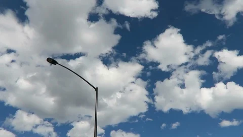 Cumulous clouds, light post pass by. Stock Footage 97386143