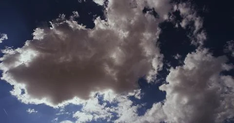 Cumulus clouds and altocumulus clouds with a passing jet . Stock Photos