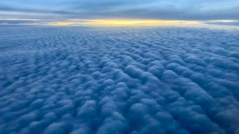 Cumulus clouds with a band of the setting sun on the horizon over the Arctic Stock Photos